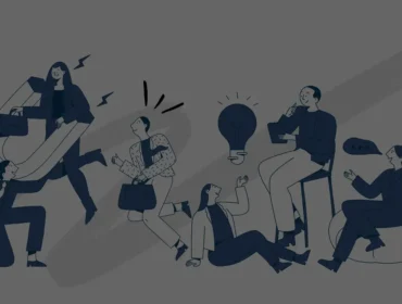 group of people brainstorming ideas around a table with a glowing light bulb in the center